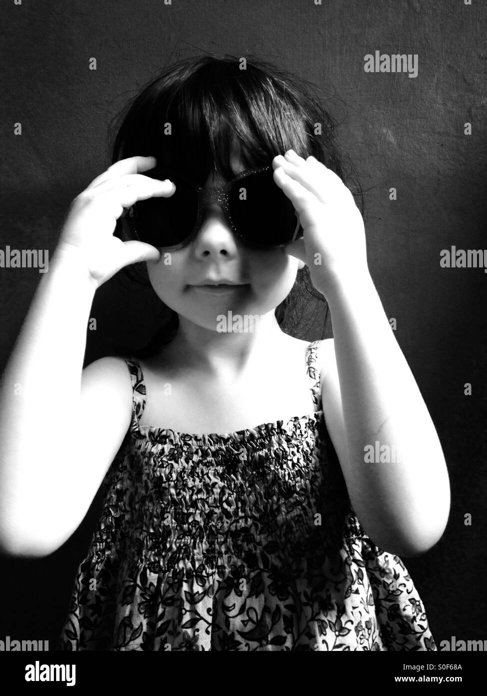 3-year old girl wearing sunglasses and summer dress. - Smartphone Captured Stock Image