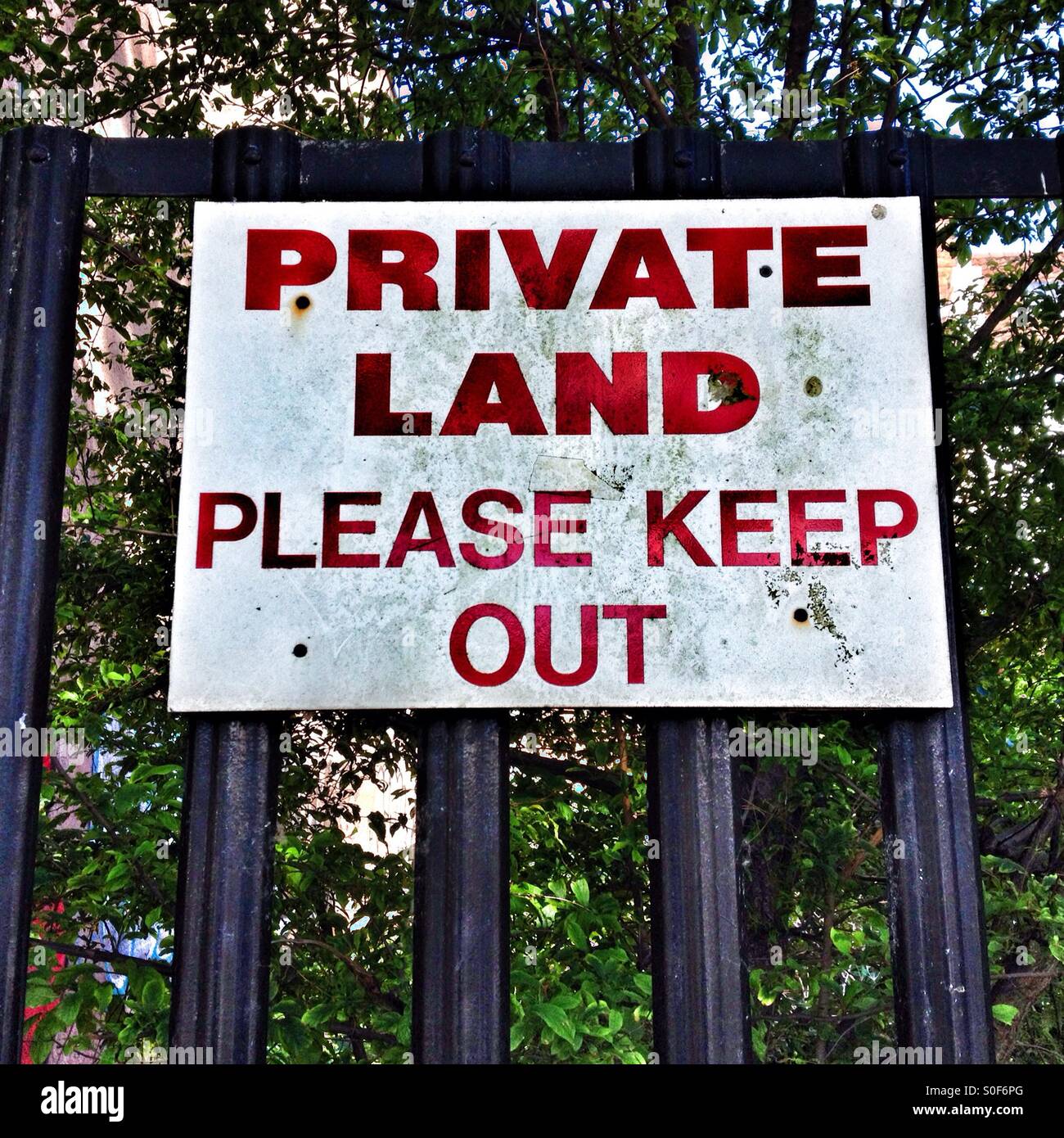 A sign reading 'PRIVATE LAND PLEASE KEEP OUT' Stock Photo