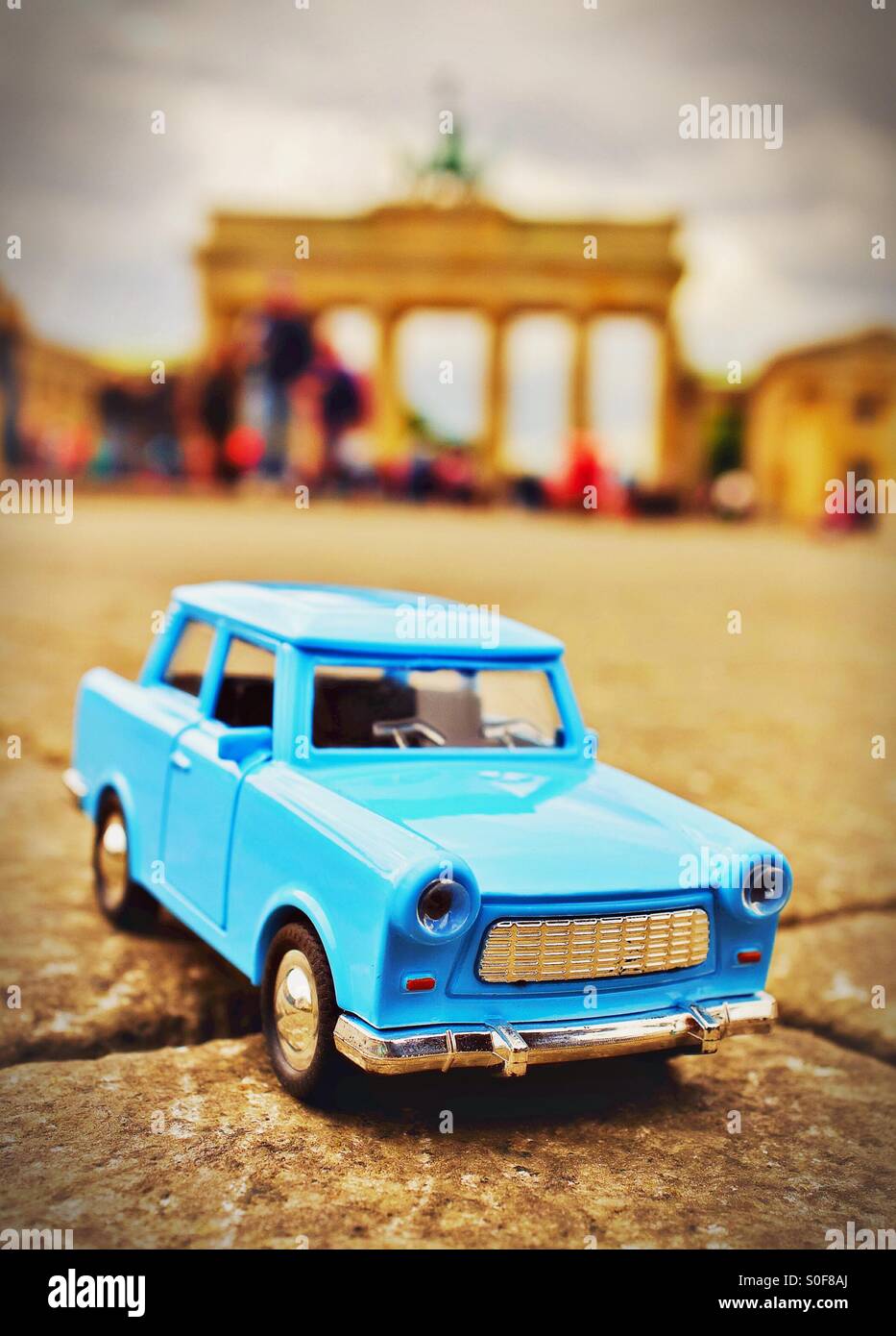 Iconic Berlin - a toy Trabant car in front of The Brandenburg Gate in Berlin Germany EU Stock Photo