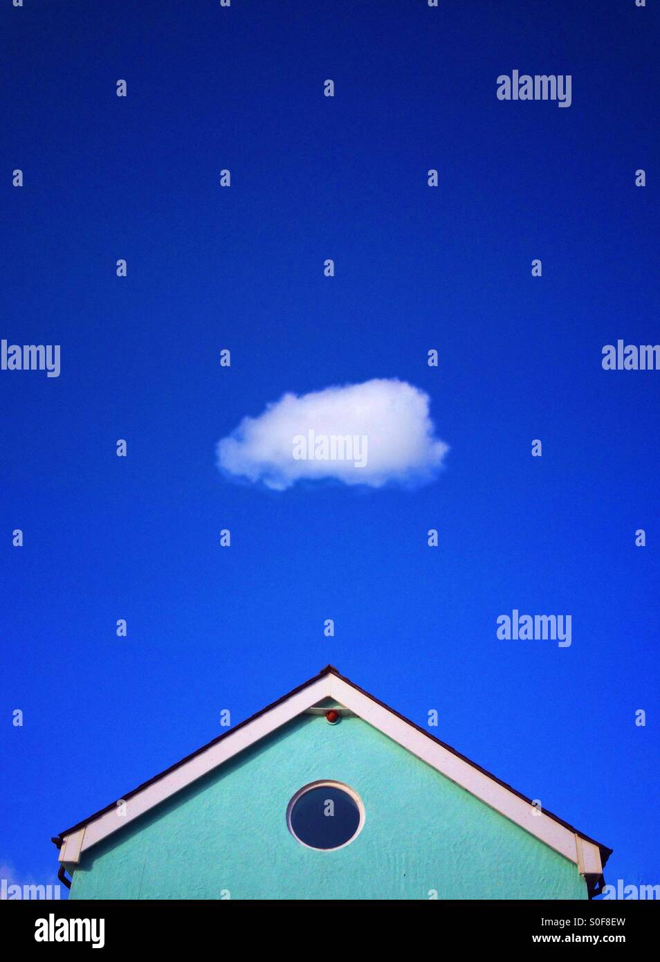 Blue house against blue sky with single fluffy cloud Stock Photo - Alamy
