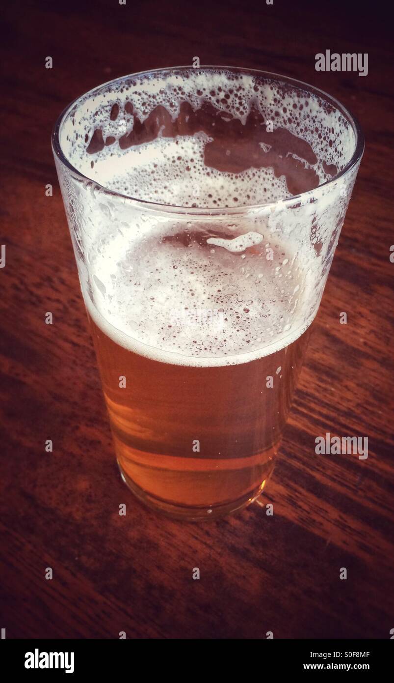 Pint glass of beer : half full or half empty Stock Photo - Alamy