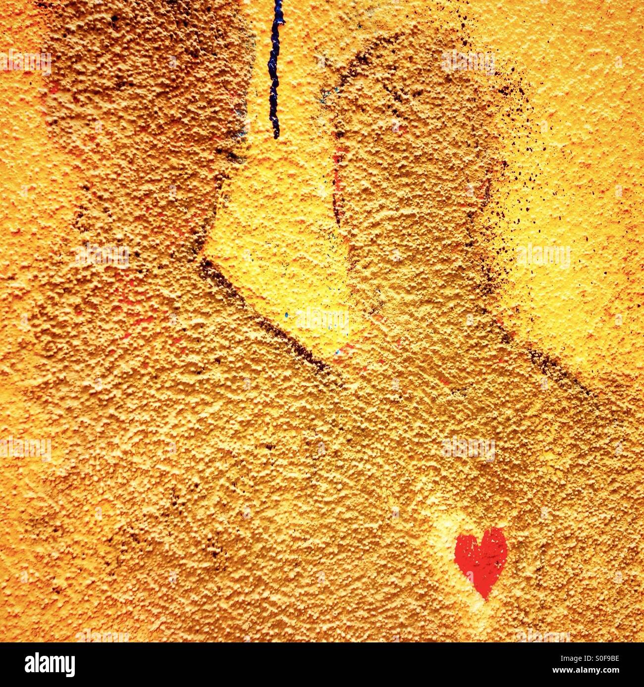 Two figures with a heart painted on a wall - Smartphone Captured Stock Image