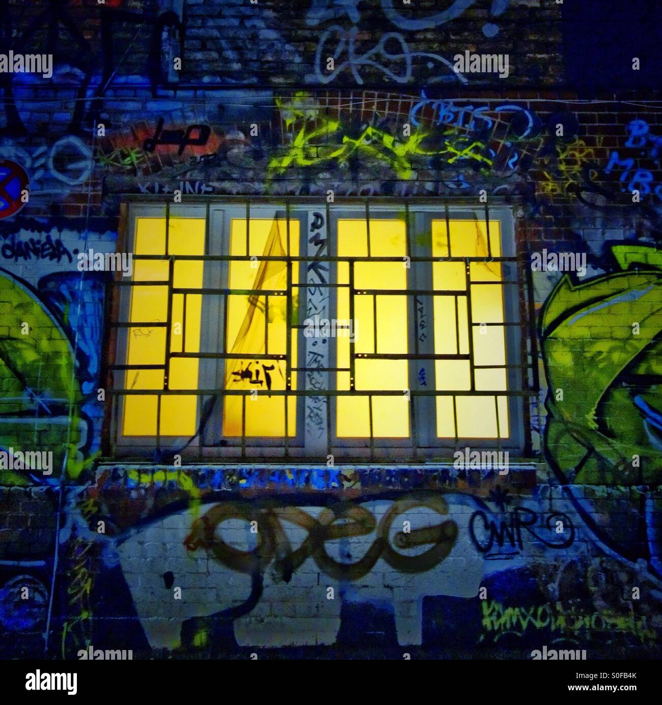 Lit window on a wall of graffiti - Smartphone Captured Stock Image