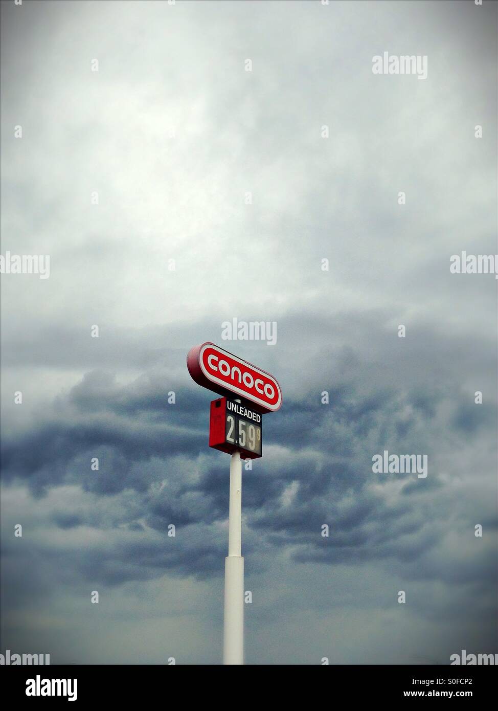 A gas station sign against a cloudy sky. Stock Photo