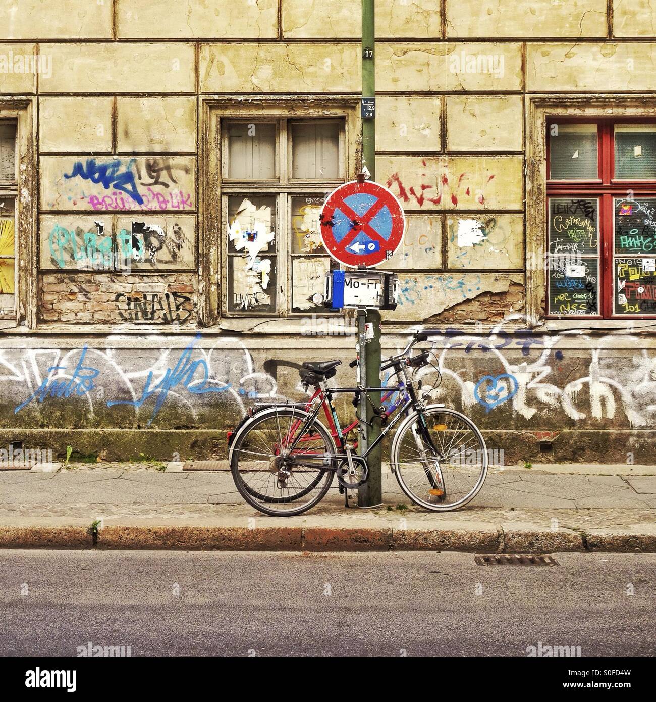 Locked bicycles on a Berlin street with graffiti Stock Photo