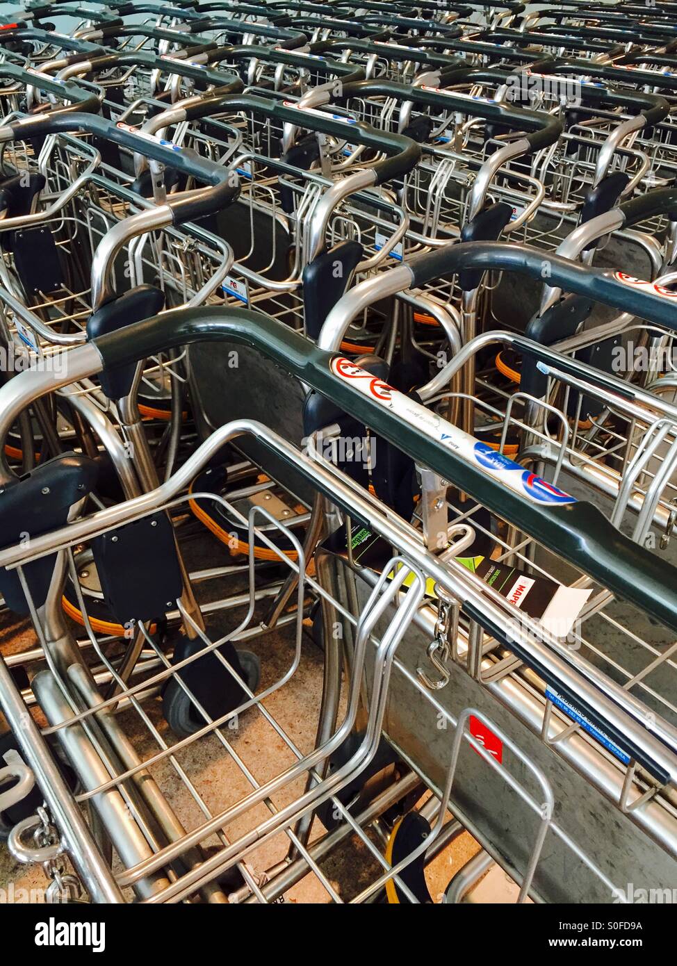 Trolly tangle. Hundreds of luggage trollies at an airport - Smartphone Captured Stock Image