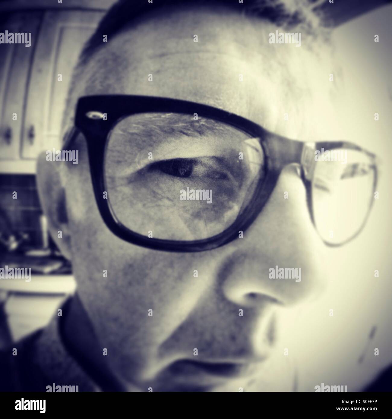 Man in glasses looking closely into camera - Smartphone Captured Stock Image