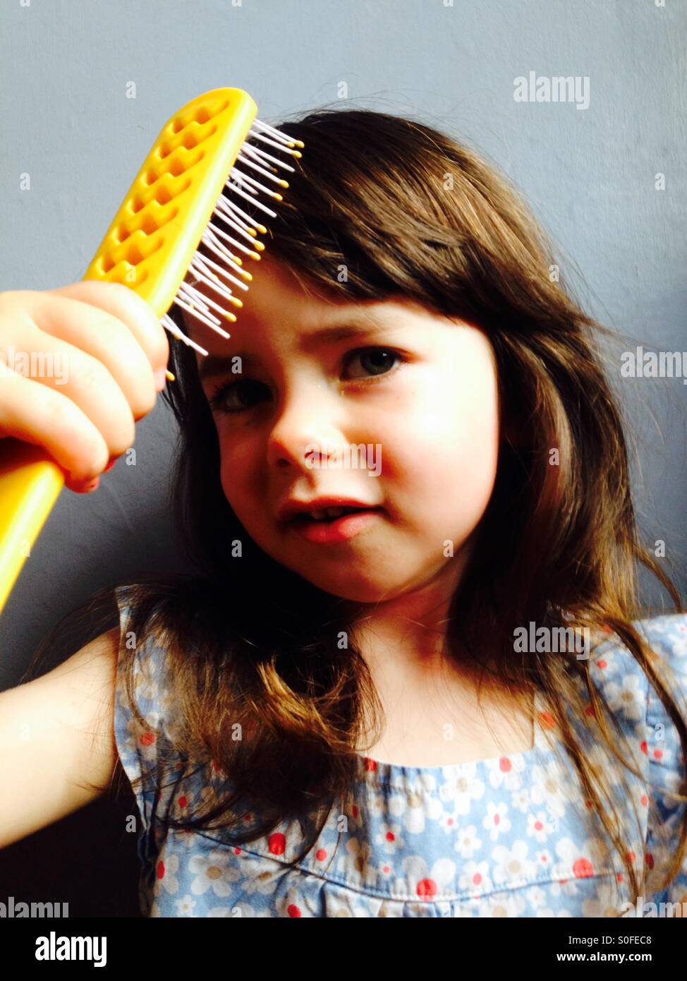 3-year old girl brushing her hair - Smartphone Captured Stock Image