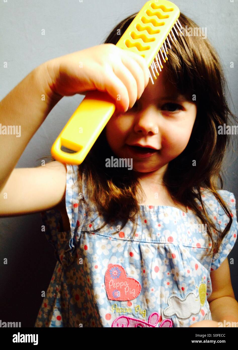 3-year old girl brushing her hair - Smartphone Captured Stock Image