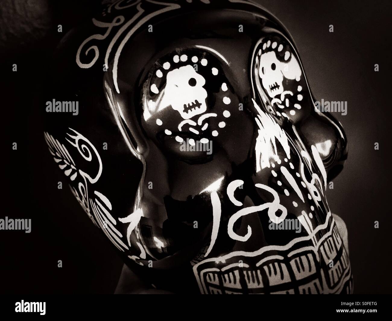 Mexican tequila bottle adorned and fashioned into the shape of a human skull. Dia de los Muertos. - Smartphone Captured Stock Image