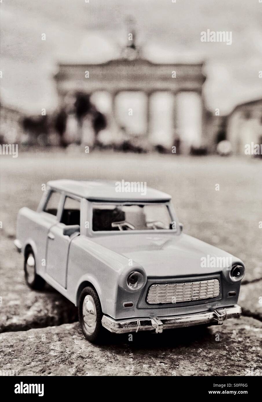 Iconic Berlin - A toy Trabant car in front of The Brandenburg Gate in Berlin Germany EU Stock Photo