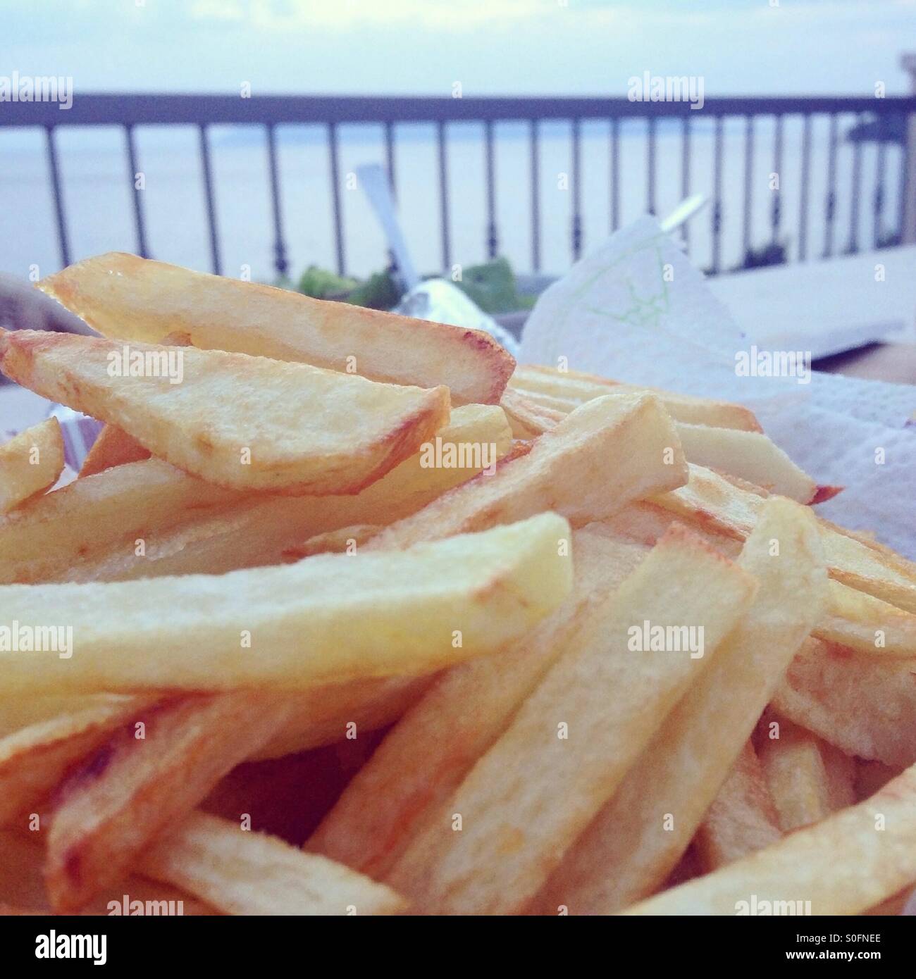 French fries at table outdoor close to sea Stock Photo