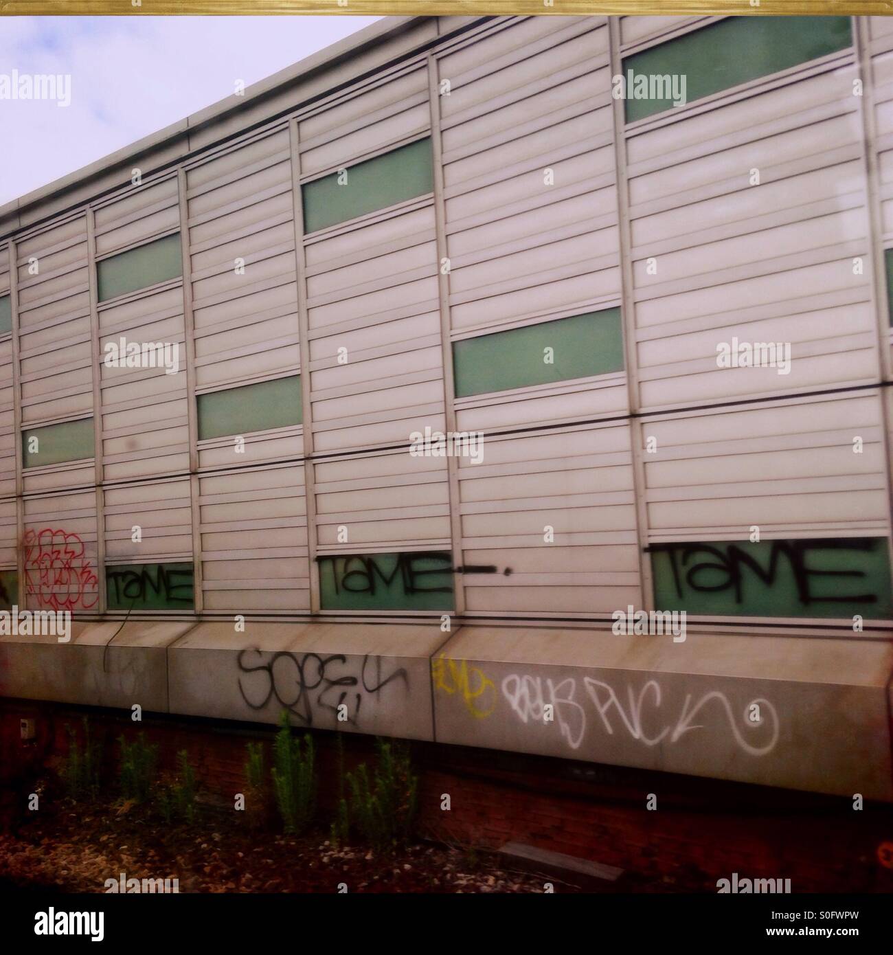 Graffitied building by train track Stock Photo