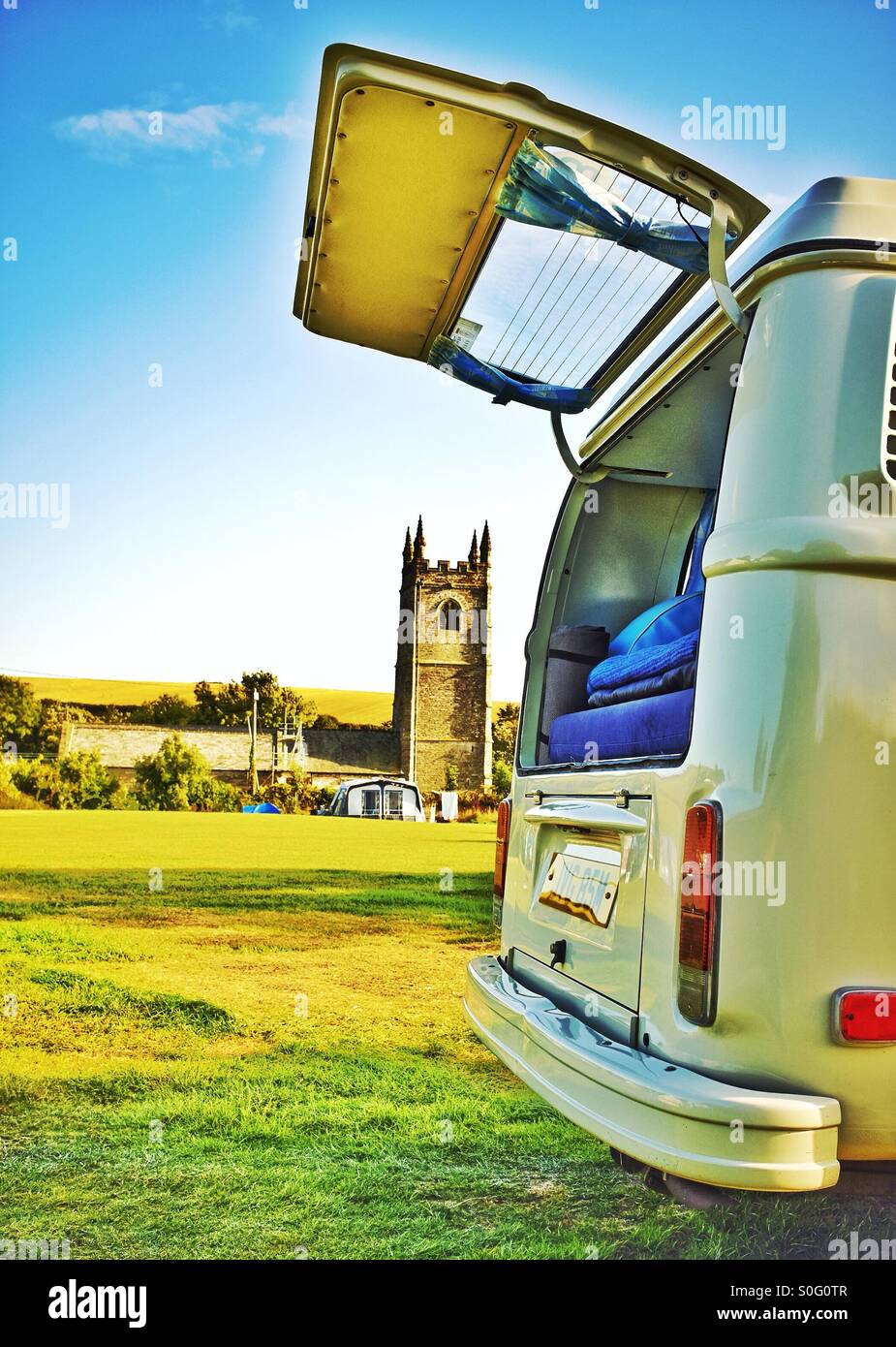 Arriving at an English countryside campsite in a classic VW camper van Stock Photo