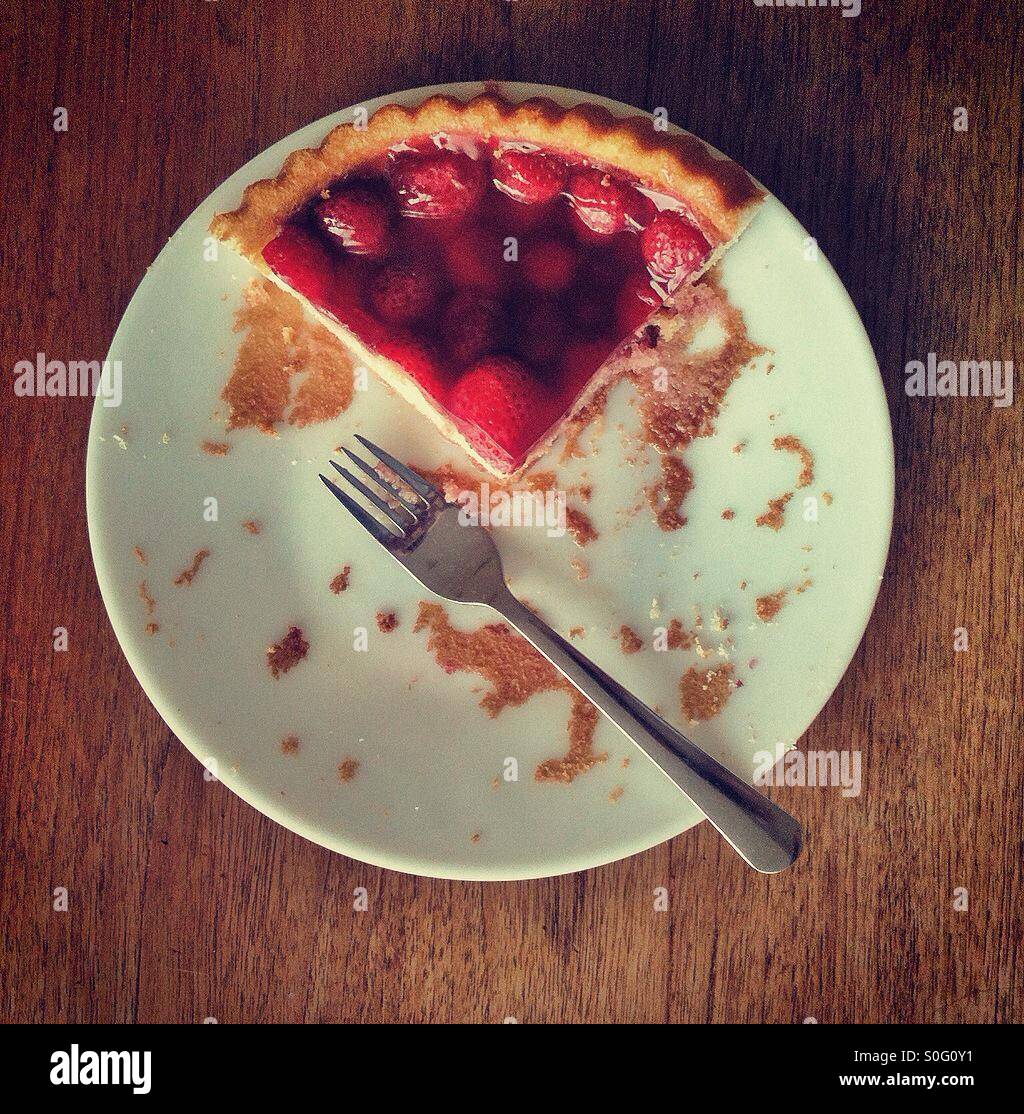 What's left of a strawberry flan and a fork. - Smartphone Captured Stock Image