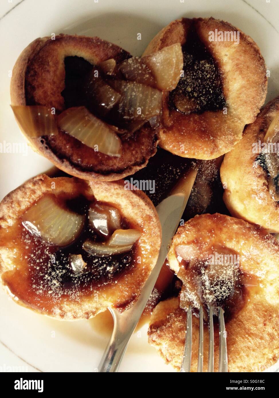 Plate of Yorkshire puddings and onion gravy Stock Photo Alamy