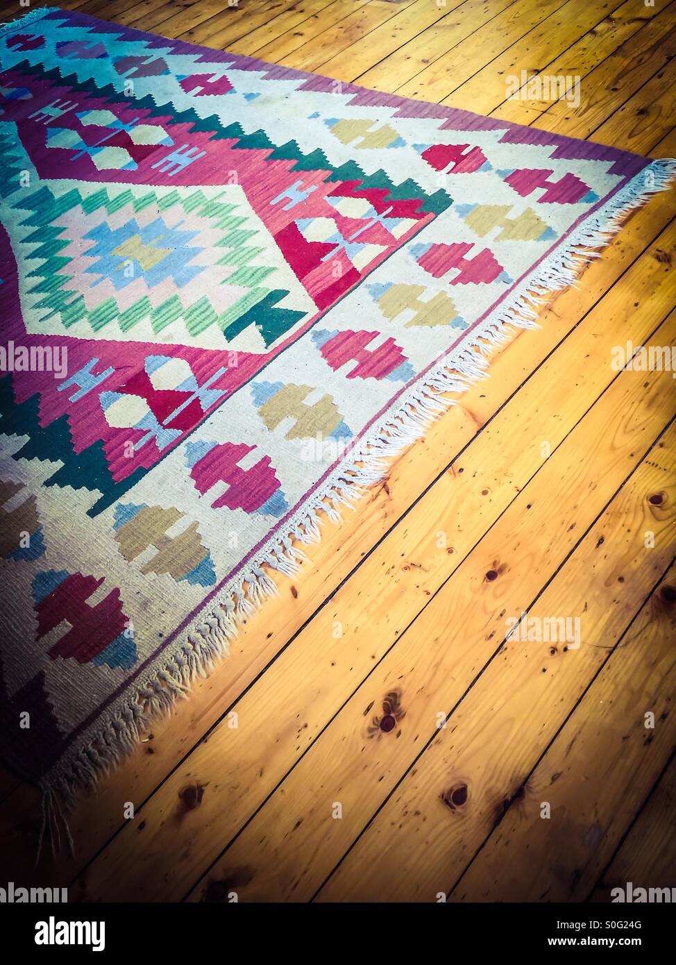 Rug on pine floor Stock Photo Alamy