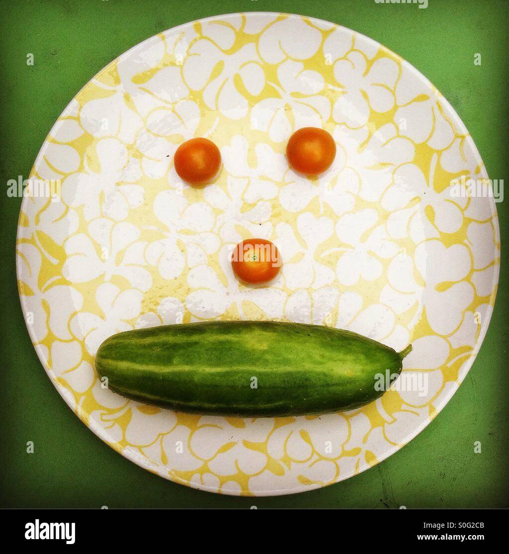 Smiley face with cherry tomatoes and cucumber. Stock Photo