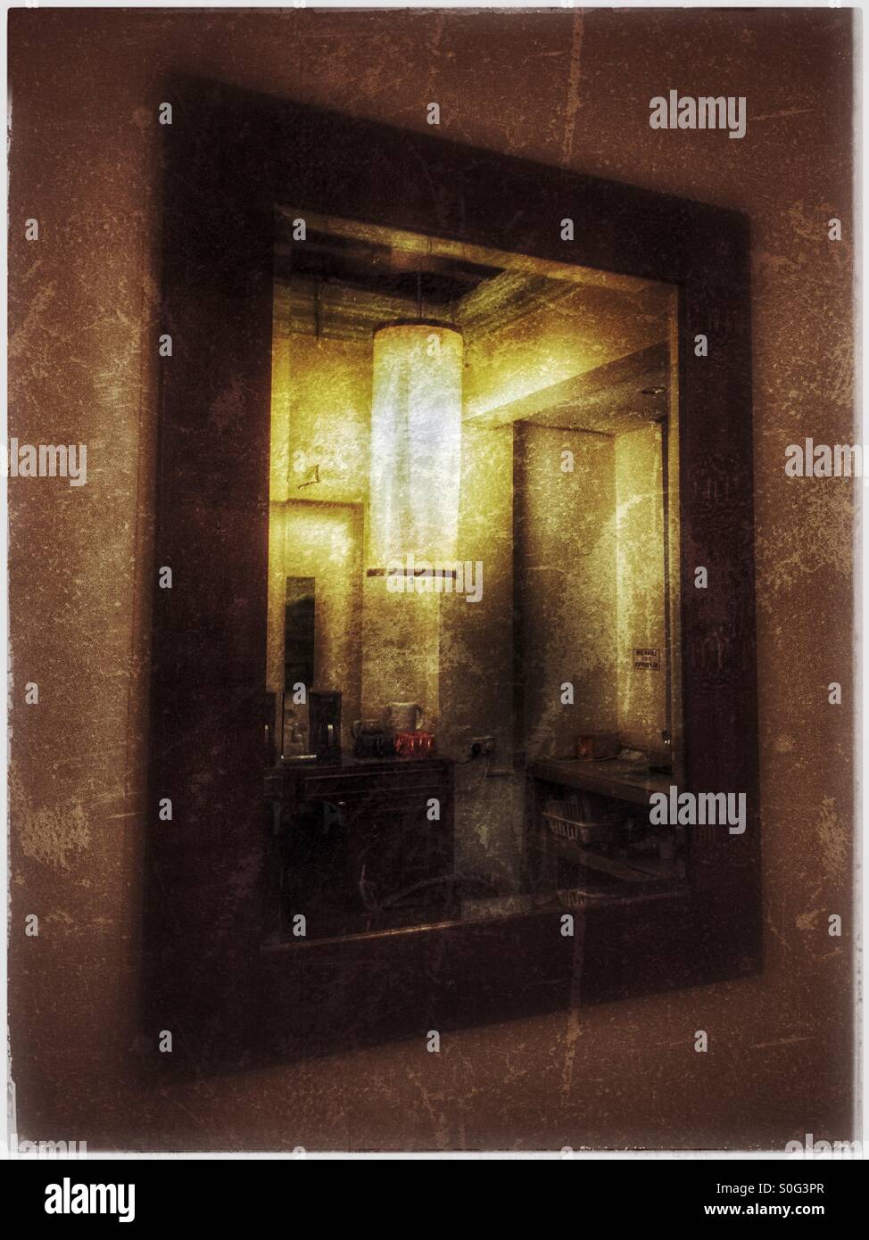 A large mirror on the kitchen wall. - Smartphone Captured Stock Image