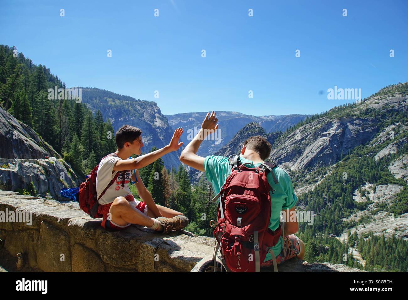 Two teenage hikers congratulate each other after trekking up Nevada Falls Stock Photo