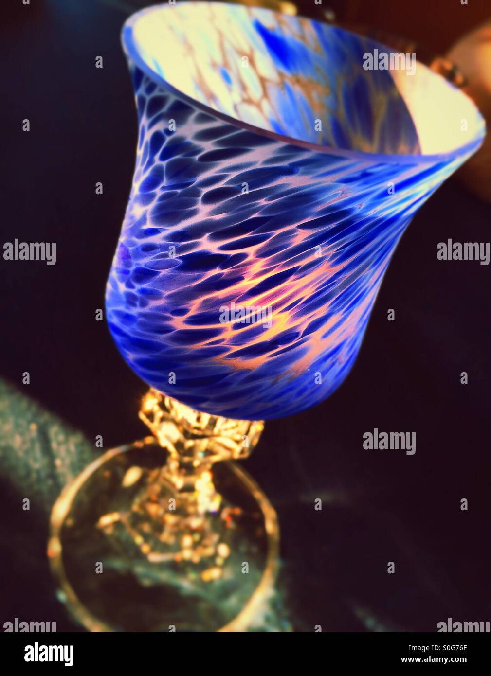 Decorative bright blue votive candle on a dining room table, USA - Smartphone Captured Stock Image