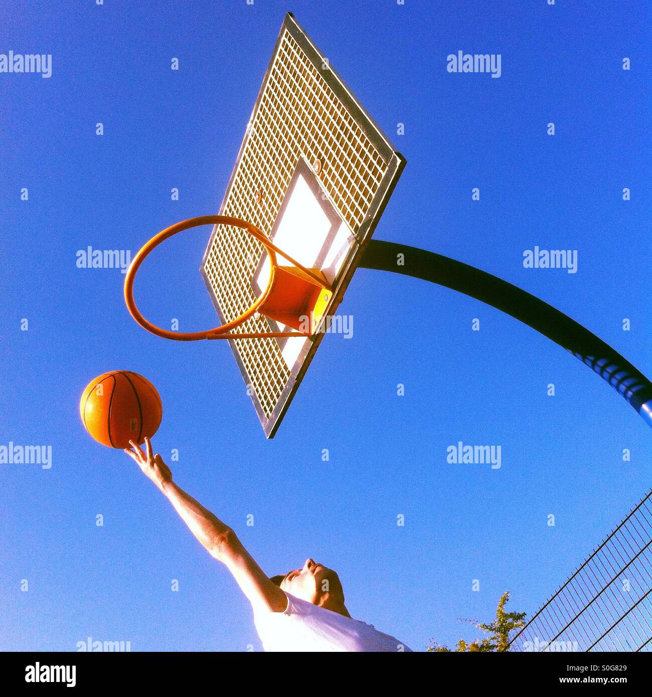 Man throwing a basketball in to the hoop Stock Photo