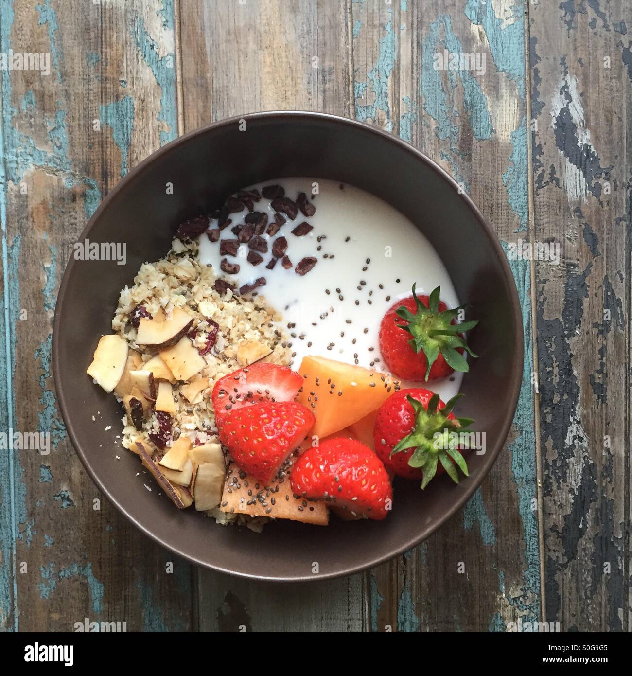 Healthy bowl of home made muesli with yogurt topped with fresh