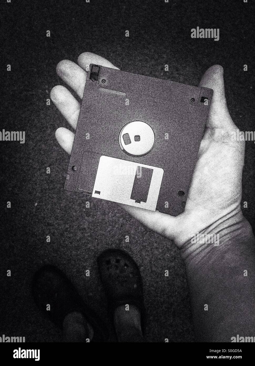 Hand holding a 3.5 inch floppy disc - Smartphone Captured Stock Image