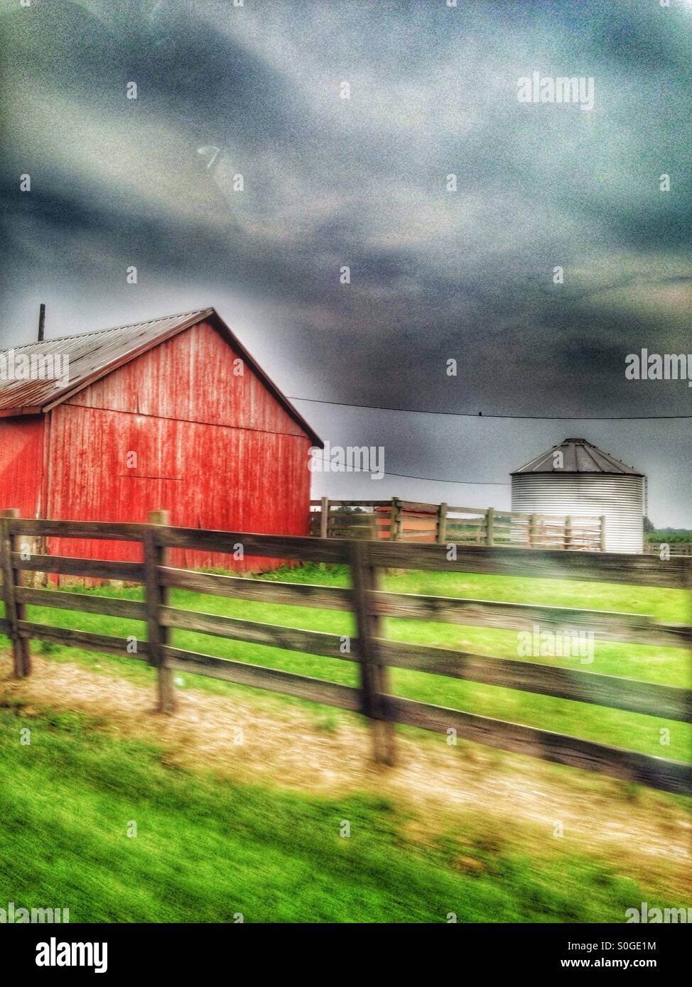 A red barn and black fence. Stock Photo