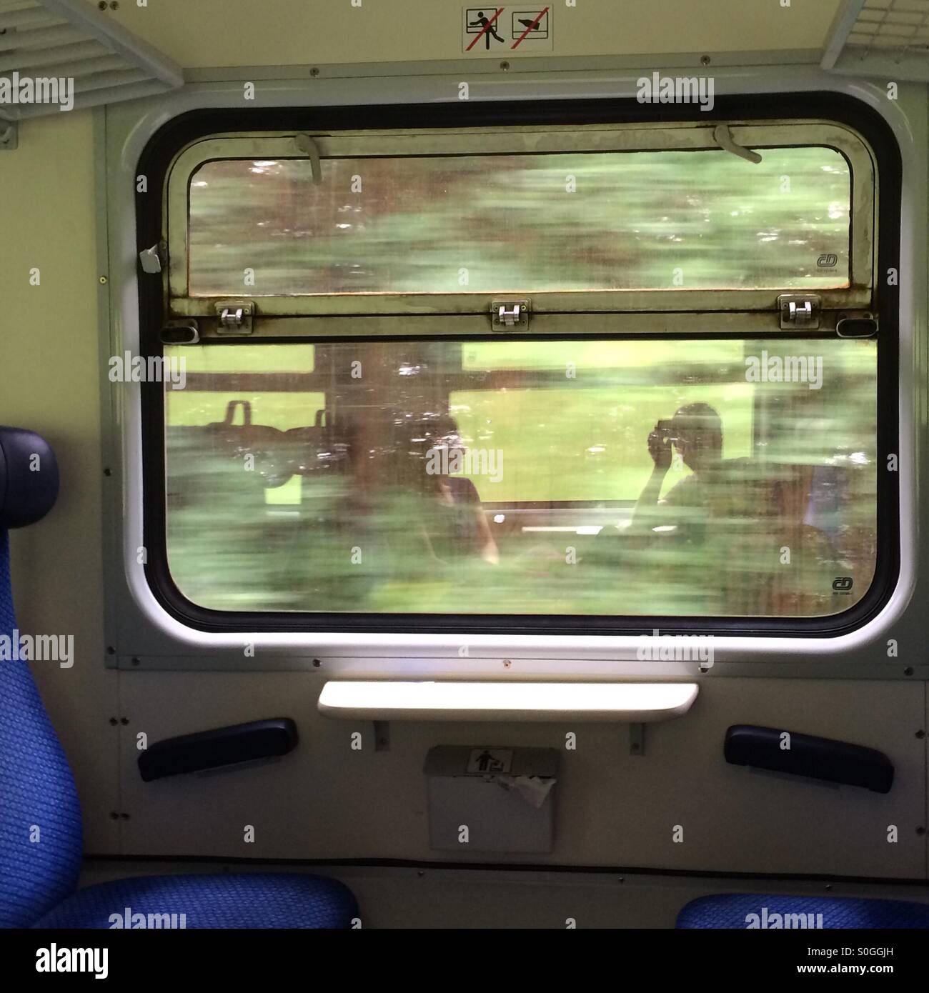 Reflections of a couple traveling by train through Eastern Europe. - Smartphone Captured Stock Image