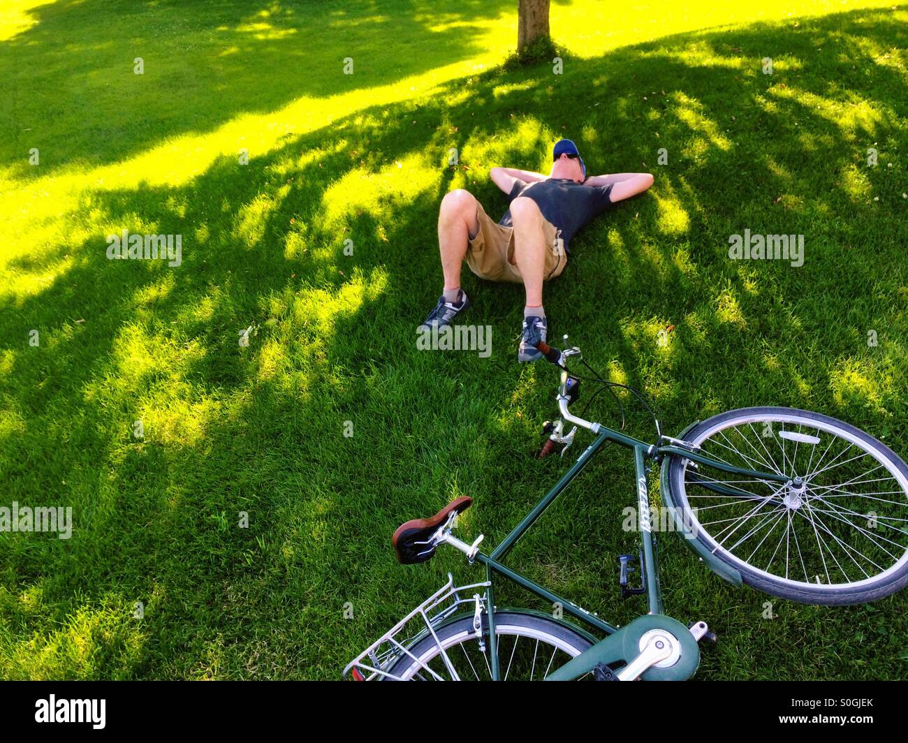 Man resting next to bike Stock Photo