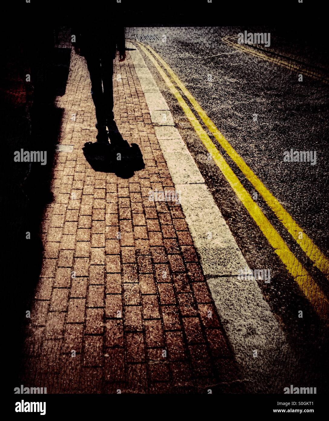 Man walking on street with long shadows - Smartphone Captured Stock Image