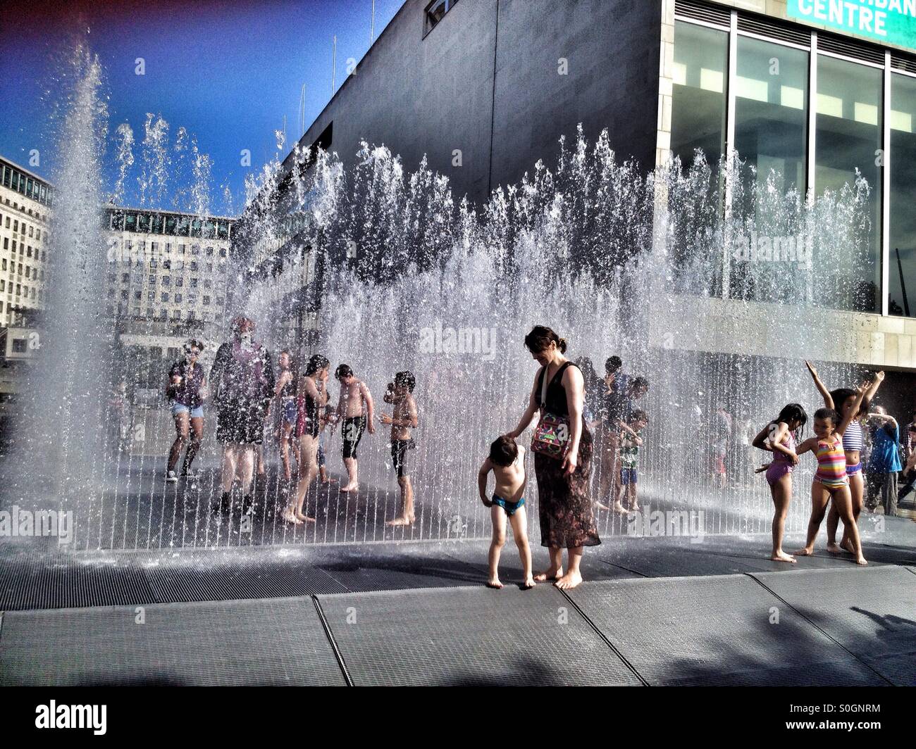 People enjoying the fountains outside the Royal Festival Hall at the Southbank Centre in London UK - Smartphone Captured Stock Image