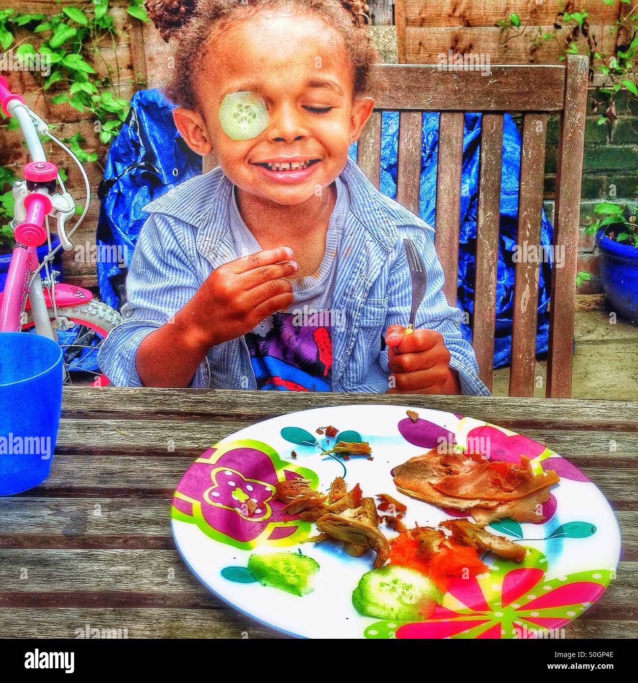 A child plays with food in the garden. Stock Photo