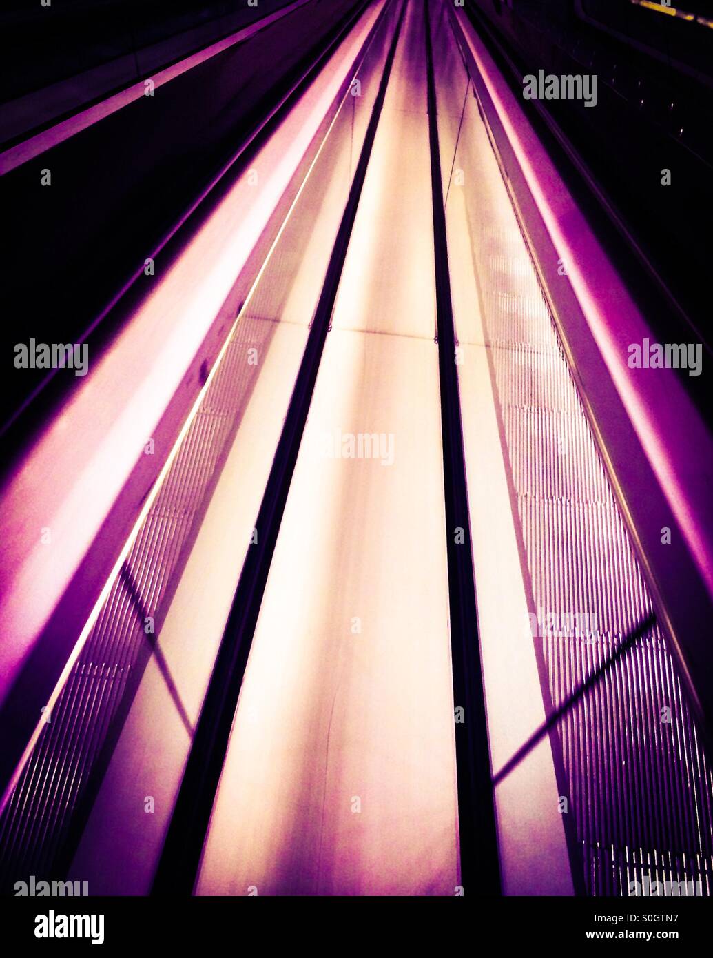 Two escalators illuminating strip lighting. Stock Photo