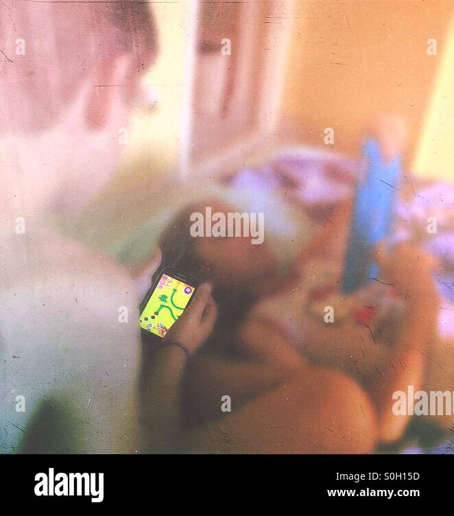 Brother and sister playing CandyCrush in their room while on holiday - Smartphone Captured Stock Image