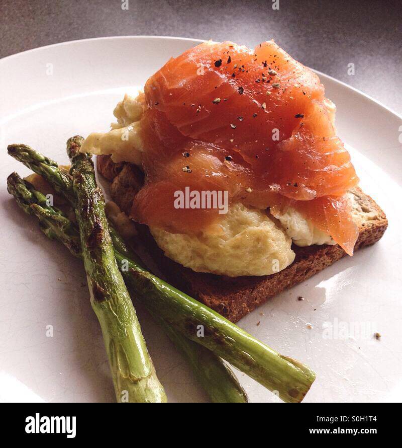 Healthy home cooked Scottish smoked salmon, scrambled egg, wholemeal toast and grilled asparagus Stock Photo