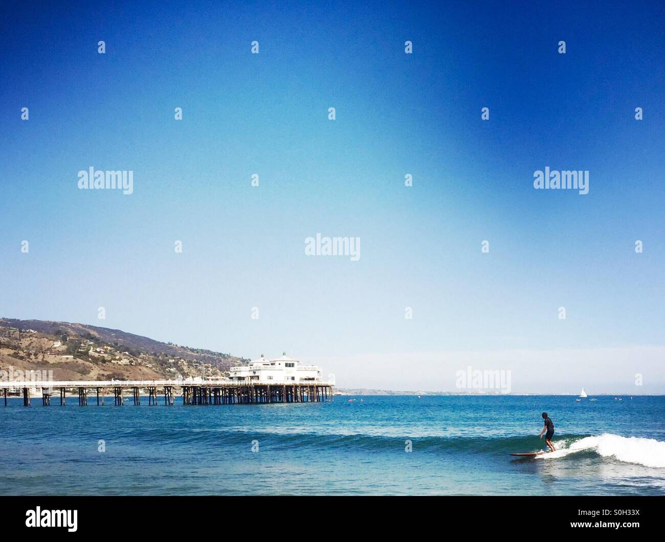 A surfer rides a wave at surfrider beach malibu, California USA. Stock Photo