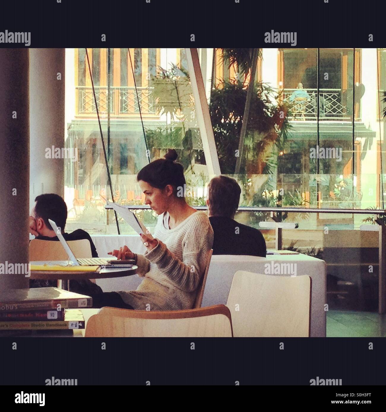 A person in a library working on her laptop - Smartphone Captured Stock Image