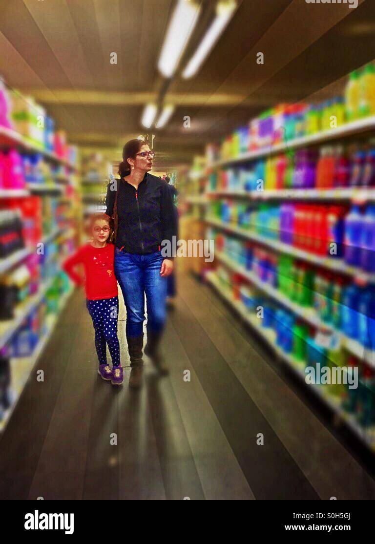 Mother and daughter amid supermarket product aisles. - Smartphone Captured Stock Image