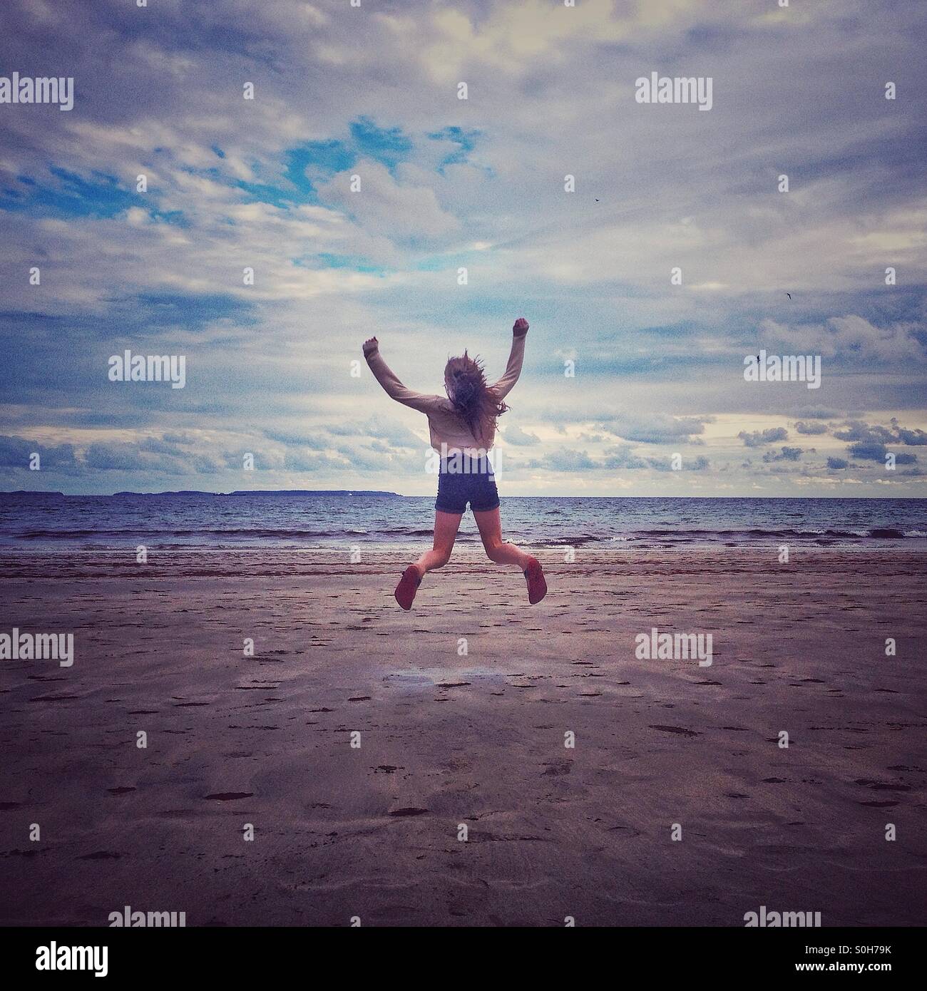 Girl jumping on beach Stock Photo