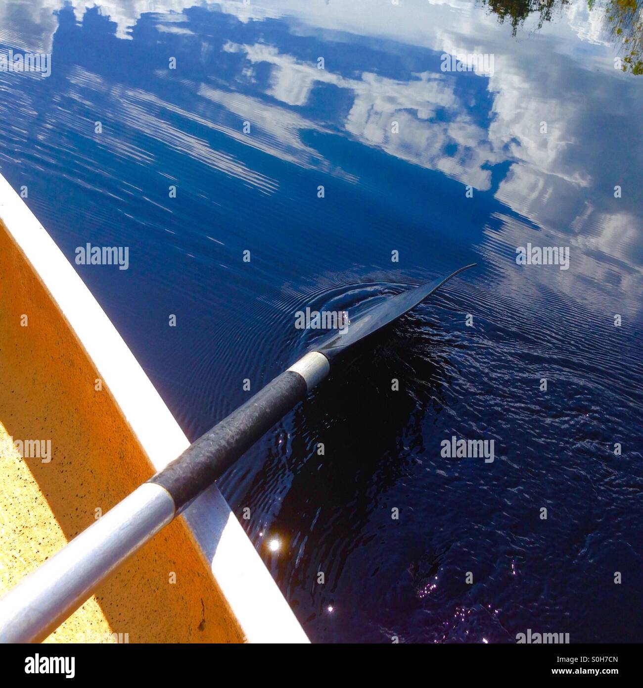 Paddling a canoe on a lake Stock Photo