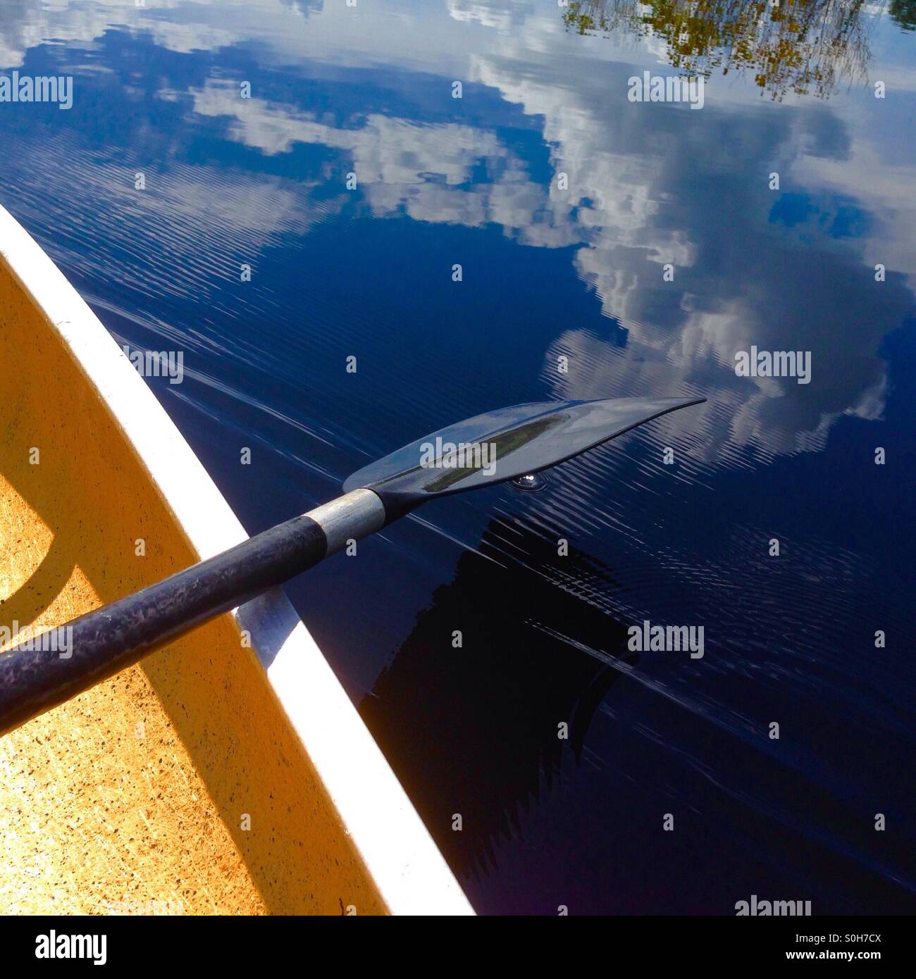 Paddling a canoe on a lake Stock Photo