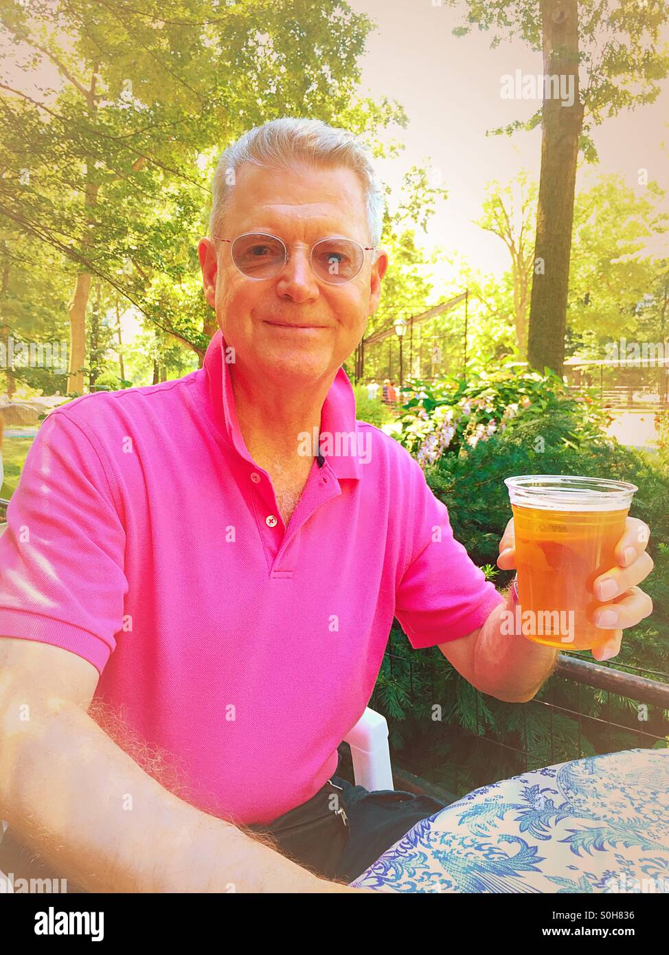 Senior man enjoying a beer in the park - Smartphone Captured Stock Image