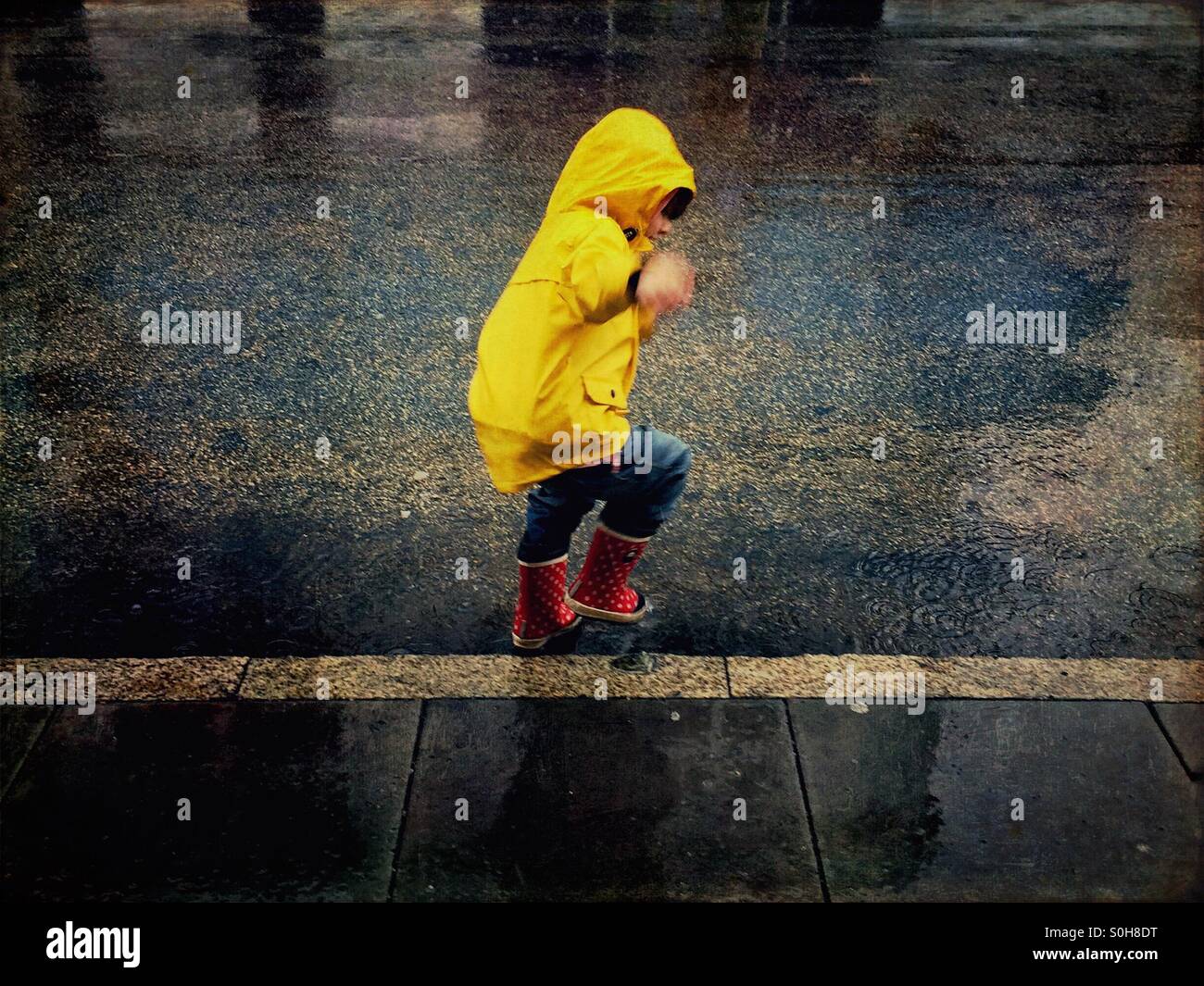 Child playing in the rain Stock Photo Alamy