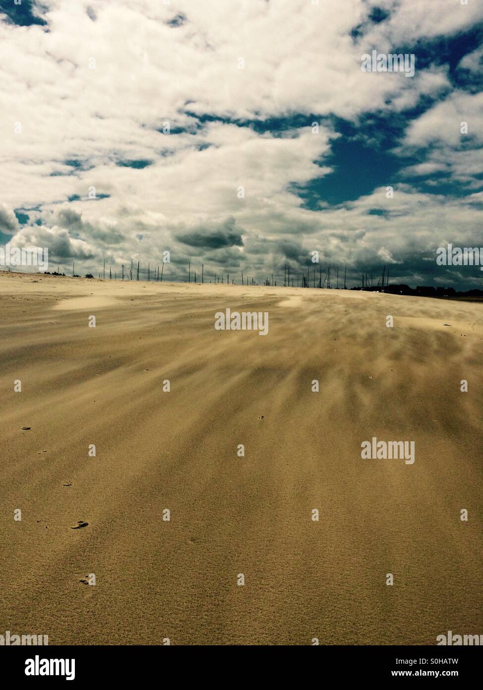 Wind whistles along sandy beach at Hayling Island - English beach. Cloudy sky on a chilly summer day. Stock Photo