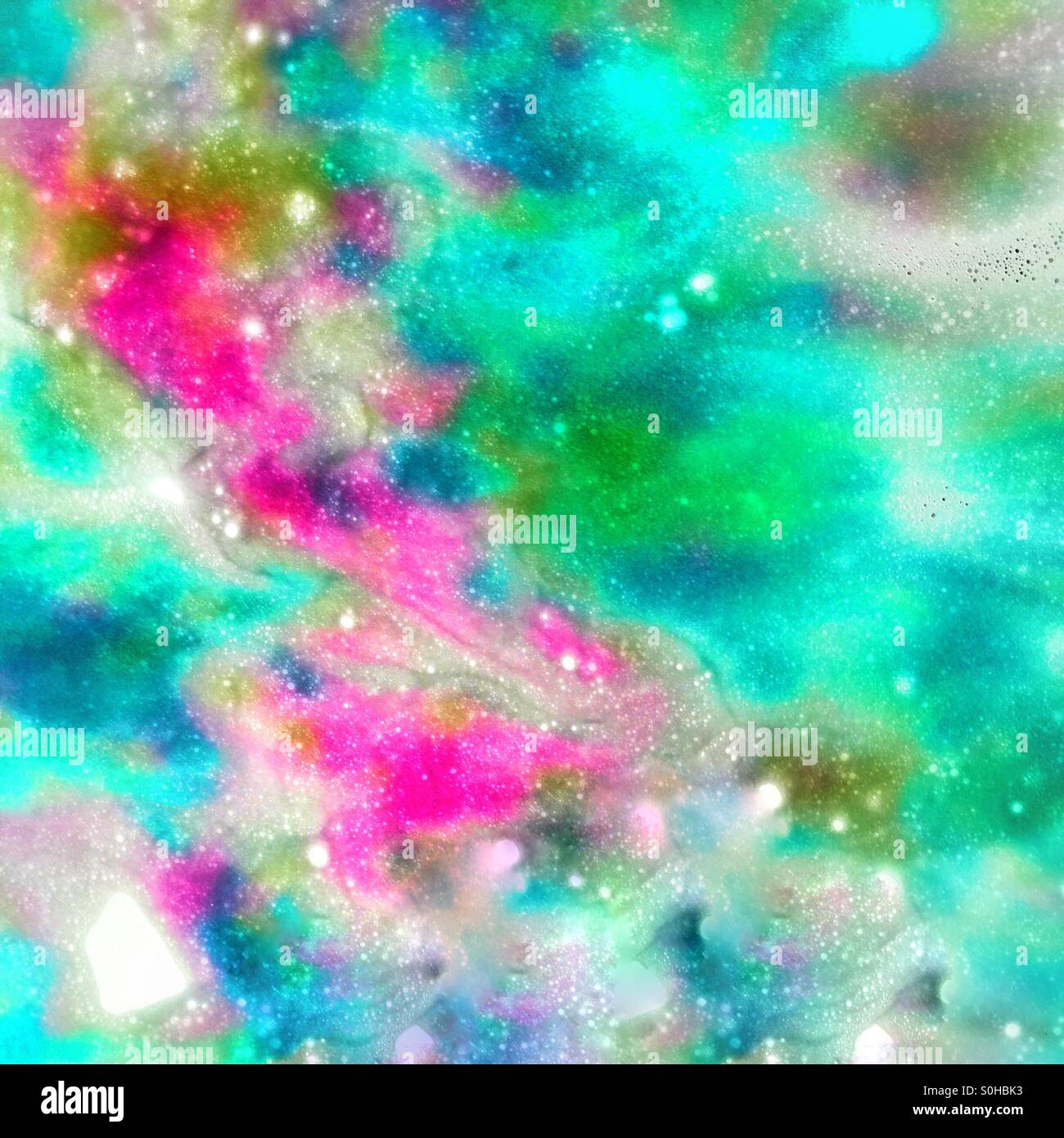 A colorful abstract artwork in pastel green, pink and blue that was created from an image of spray soap that was used during a drive through car wash Stock Photo