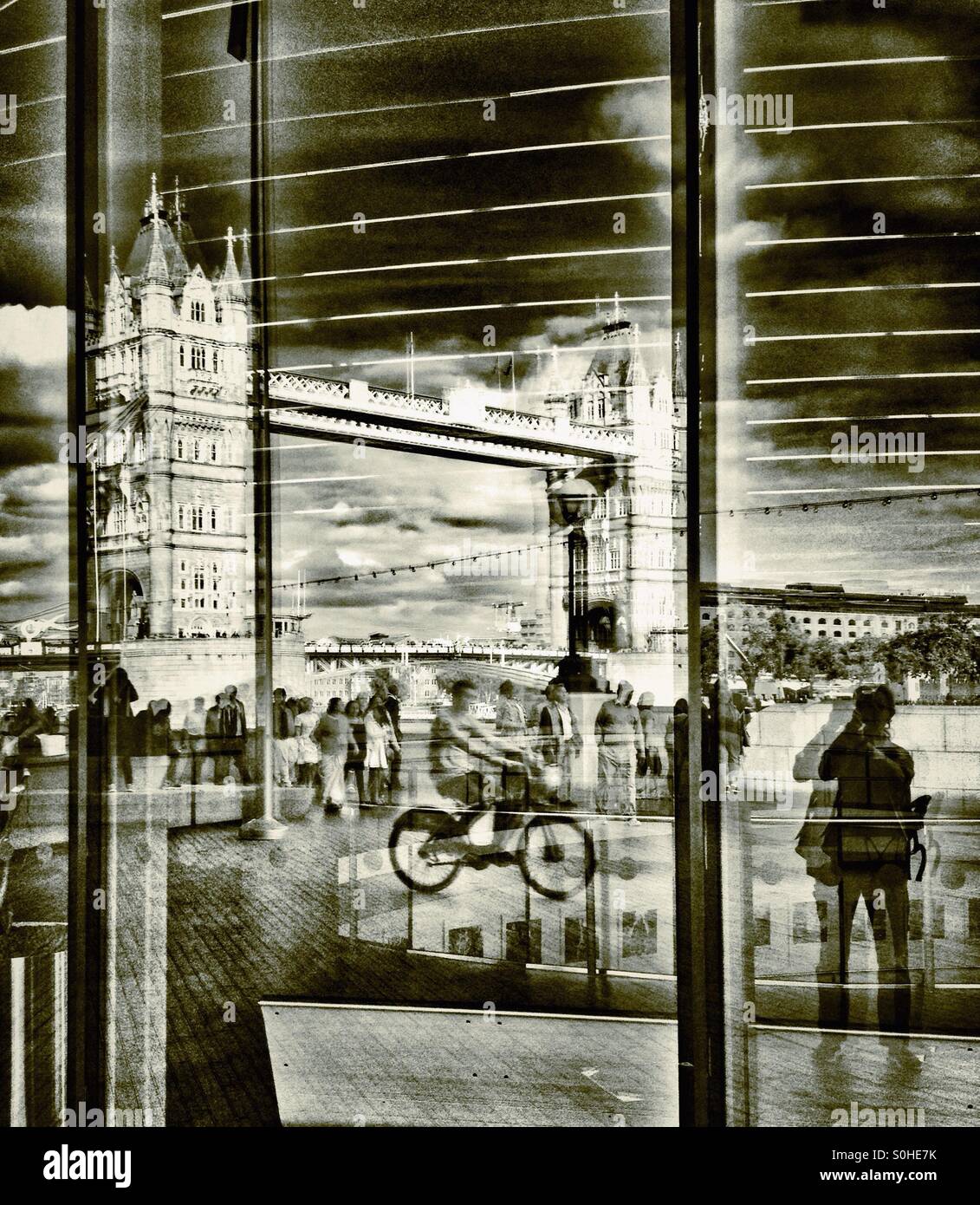 Tower Bridge and cyclist reflected in the windows of City Hall London England UK - Smartphone Captured Stock Image