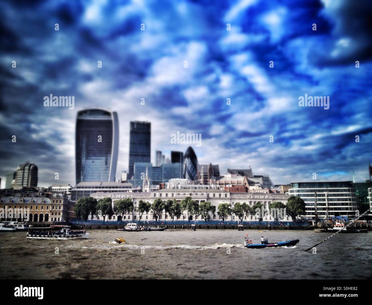 Pleasure boats float down the river Thames with the skyscrapers of the financial district in the background - Smartphone Captured Stock Image