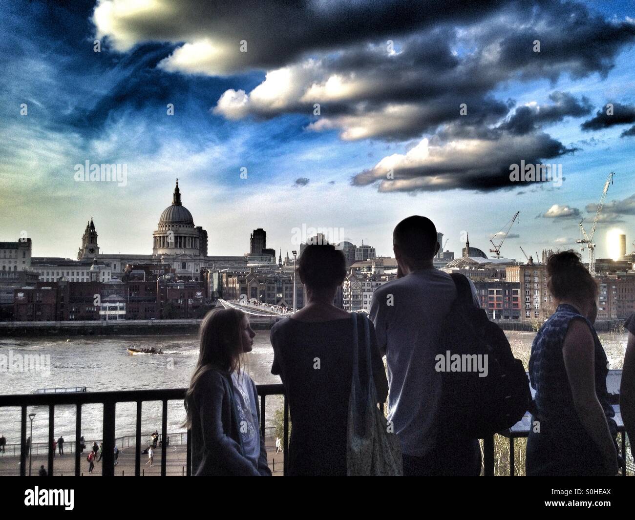 Tourists enjoy a view of London from a viewing balcony in the Tate Modern art gallery - Smartphone Captured Stock Image
